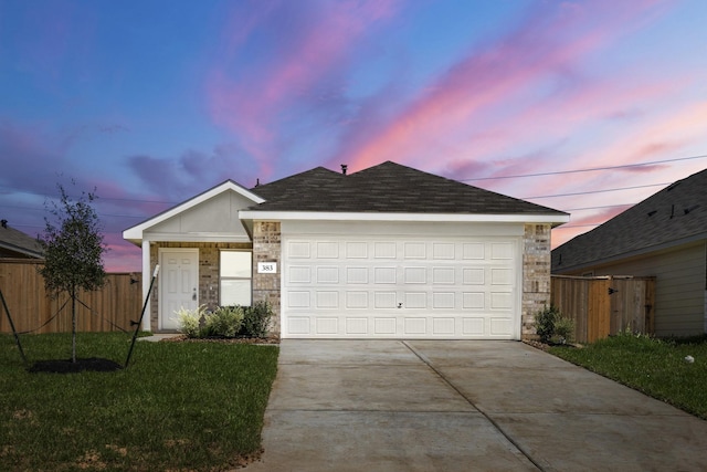 ranch-style home with a garage and a yard