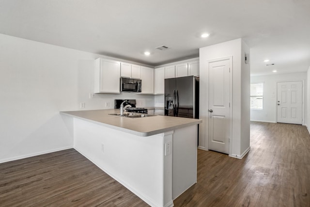 kitchen featuring dark hardwood / wood-style floors, black appliances, white cabinetry, sink, and kitchen peninsula