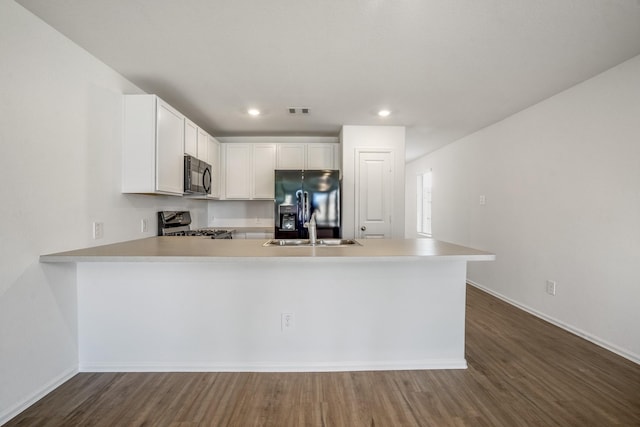 kitchen featuring sink, black appliances, kitchen peninsula, and white cabinets