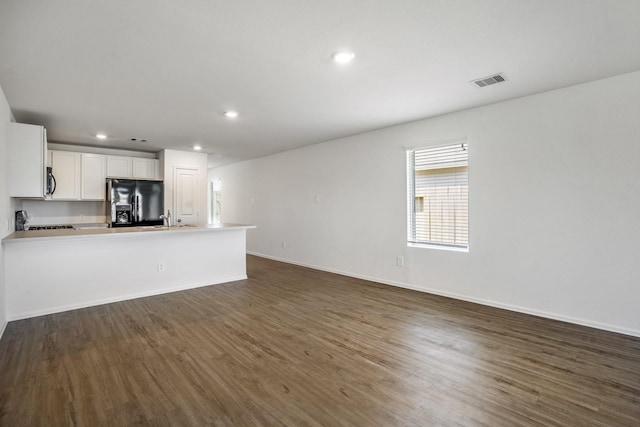 unfurnished living room with sink and dark hardwood / wood-style flooring