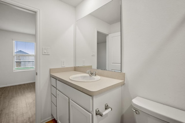 bathroom with vanity, hardwood / wood-style flooring, and toilet