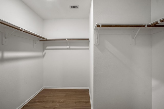 spacious closet featuring dark hardwood / wood-style floors