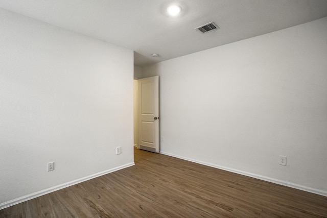 unfurnished room with dark wood-type flooring