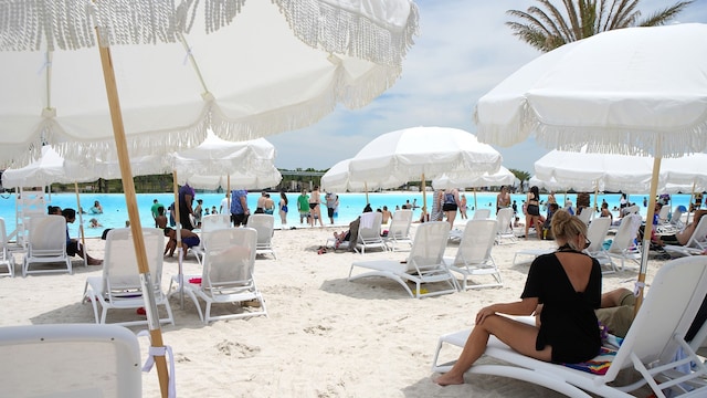 view of property's community with a water view and a beach view