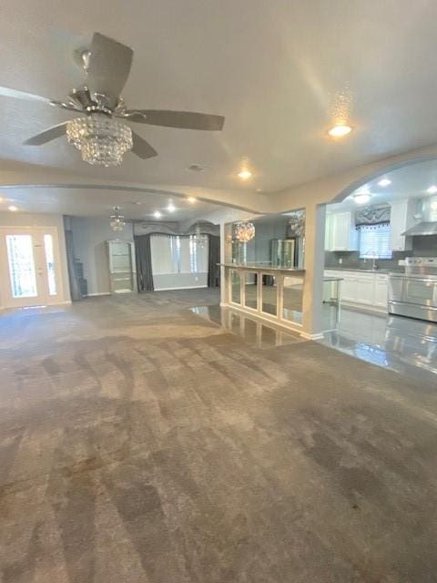 unfurnished living room featuring ceiling fan and carpet