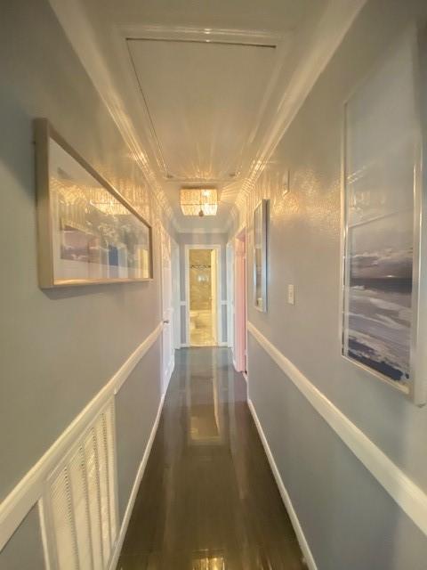 hall with ornamental molding and dark wood-type flooring