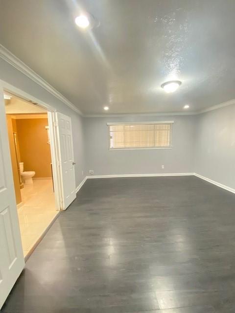 unfurnished room featuring ornamental molding and dark hardwood / wood-style floors