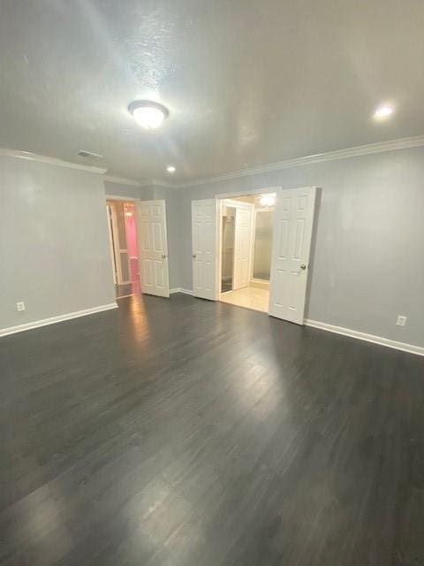 spare room with dark wood-type flooring and crown molding