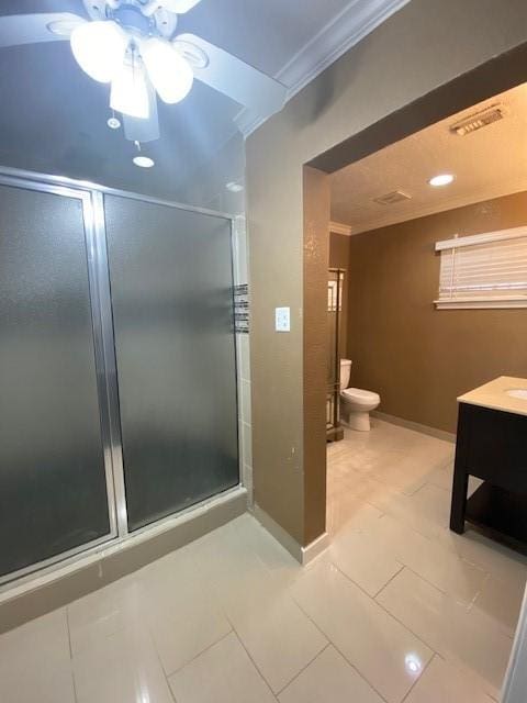 bathroom with crown molding, tile patterned flooring, vanity, a shower with shower door, and toilet