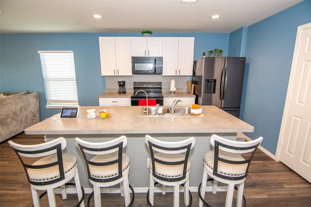 kitchen featuring sink, dark wood-type flooring, white cabinetry, a kitchen island with sink, and black appliances