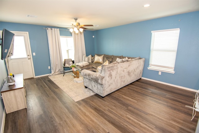 living room with dark wood-type flooring and ceiling fan