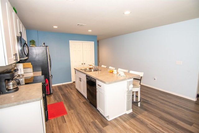 kitchen featuring dark wood-type flooring, sink, white cabinetry, an island with sink, and black appliances