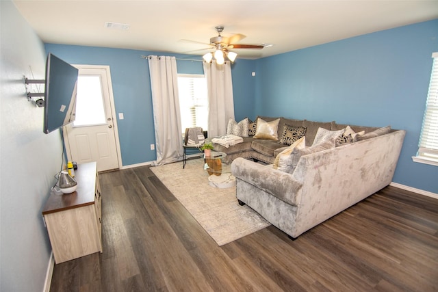 living room with dark wood-type flooring and ceiling fan