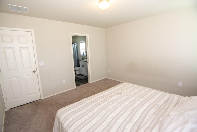 carpeted bedroom featuring ensuite bath