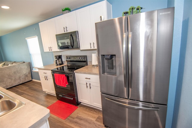 kitchen featuring sink, hardwood / wood-style flooring, black appliances, and white cabinets