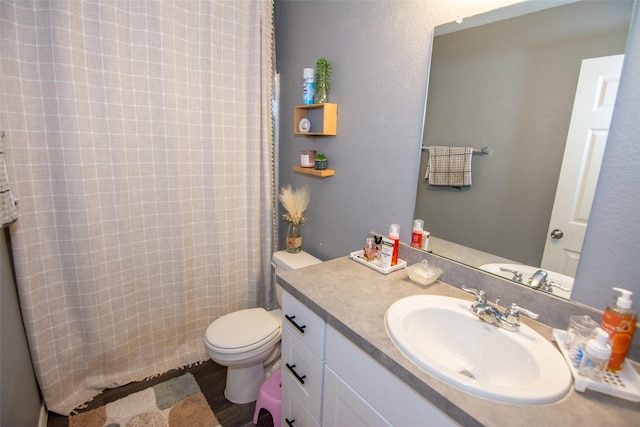 bathroom featuring walk in shower, vanity, toilet, and wood-type flooring