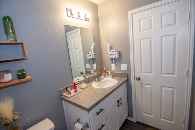 bathroom with vanity, wood-type flooring, and toilet