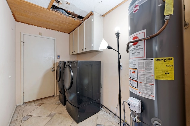 clothes washing area featuring cabinets, washer and clothes dryer, water heater, and light tile patterned floors