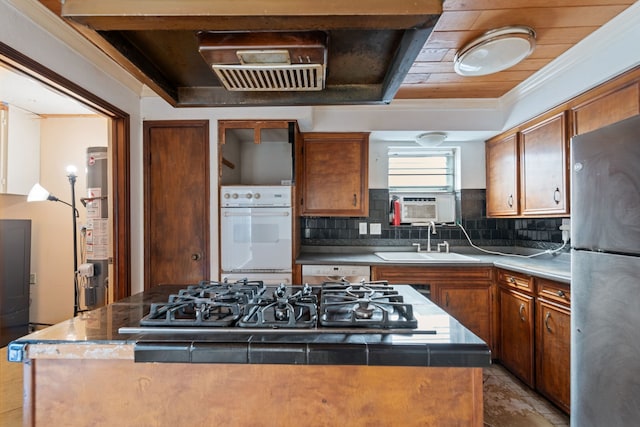 kitchen featuring sink, stainless steel fridge, a center island, gas stovetop, and oven