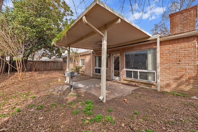 rear view of house featuring ceiling fan and a patio area