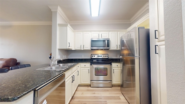 kitchen with sink, light hardwood / wood-style flooring, appliances with stainless steel finishes, white cabinets, and kitchen peninsula