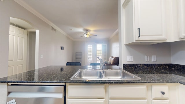 kitchen featuring sink, white cabinetry, dark stone countertops, ornamental molding, and ceiling fan