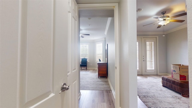 hall featuring crown molding, light hardwood / wood-style floors, and french doors