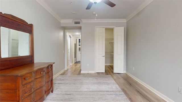 corridor with ornamental molding and light hardwood / wood-style floors