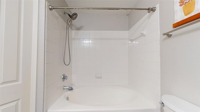 bathroom featuring toilet and tiled shower / bath combo