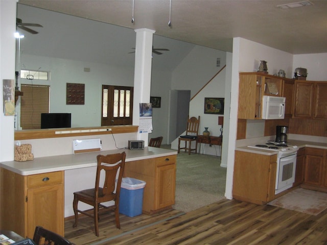 kitchen featuring a kitchen breakfast bar, dark hardwood / wood-style flooring, ceiling fan, kitchen peninsula, and white appliances