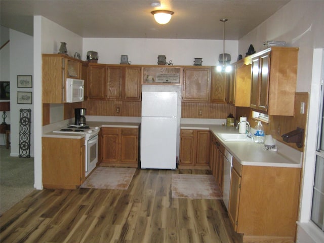 kitchen with pendant lighting, white appliances, dark wood-type flooring, and sink