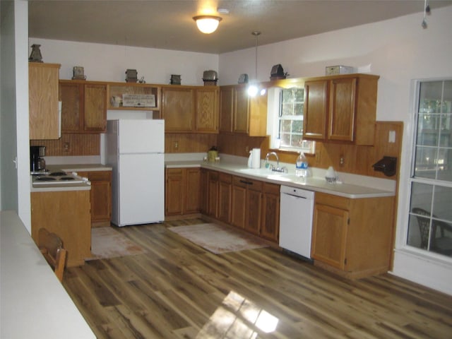 kitchen featuring pendant lighting, white appliances, dark hardwood / wood-style flooring, and sink