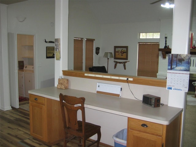 kitchen with dark hardwood / wood-style flooring, built in desk, and washing machine and dryer