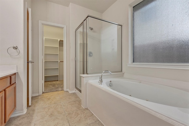 bathroom featuring plus walk in shower, vanity, and tile patterned floors