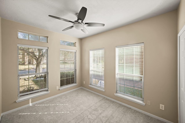 carpeted spare room with ceiling fan