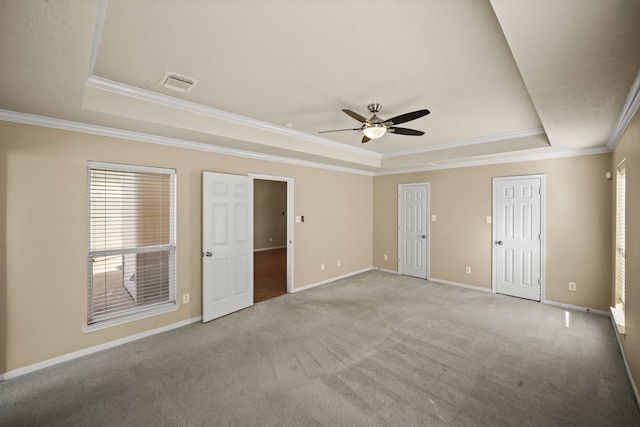 unfurnished room with crown molding, light colored carpet, and a tray ceiling