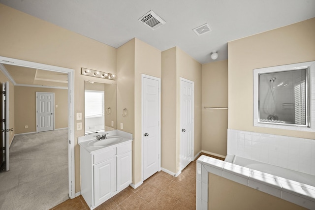 bathroom with vanity, tile patterned flooring, and tiled bath