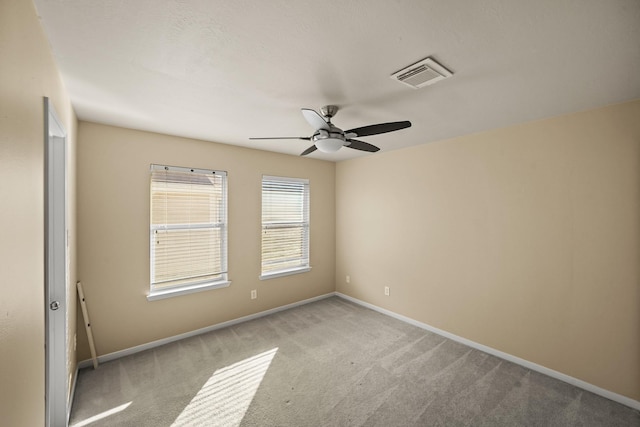 carpeted spare room featuring ceiling fan