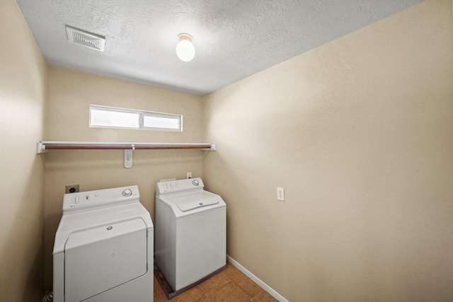 laundry room featuring washer and clothes dryer and a textured ceiling