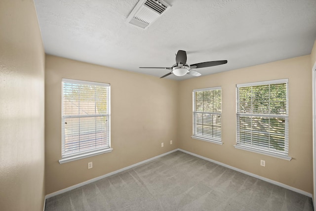 carpeted empty room featuring ceiling fan and a textured ceiling