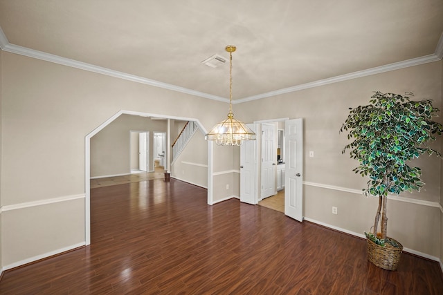 unfurnished dining area featuring dark wood-type flooring, crown molding, and a chandelier