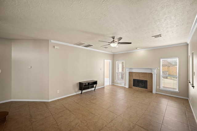 unfurnished living room with crown molding, ceiling fan, tile patterned flooring, a fireplace, and a textured ceiling