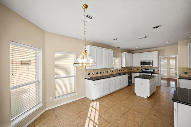 kitchen featuring pendant lighting, white cabinets, and appliances with stainless steel finishes