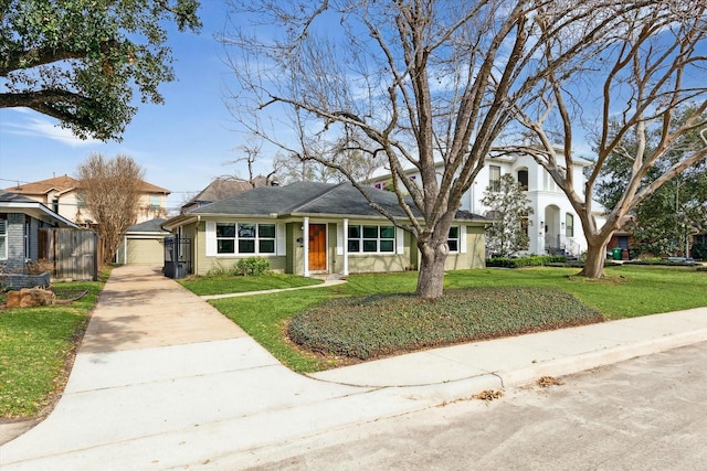 view of front facade featuring a garage, an outbuilding, and a front lawn