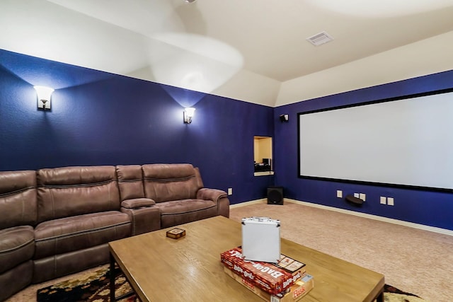 carpeted cinema room with lofted ceiling, visible vents, and baseboards