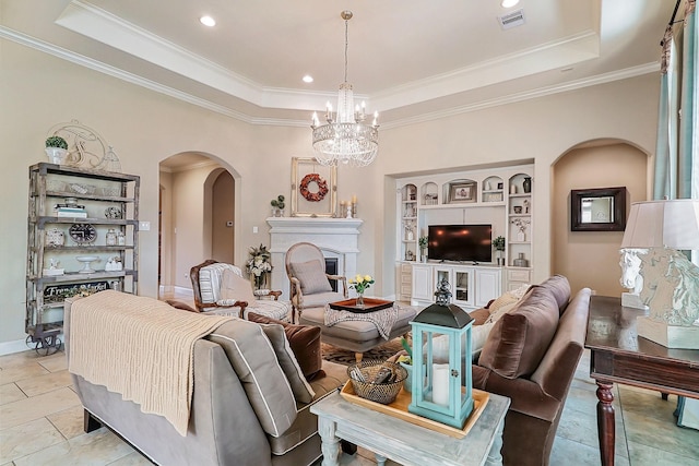 living area featuring visible vents, a raised ceiling, crown molding, and a glass covered fireplace