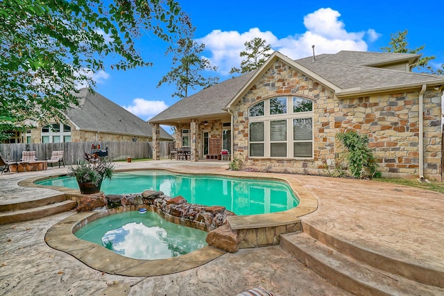 view of pool with a fenced in pool, fence, a patio, and an in ground hot tub