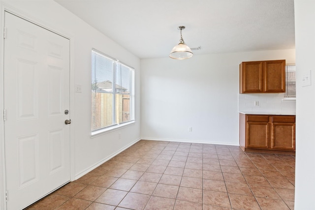 unfurnished dining area featuring light tile patterned floors