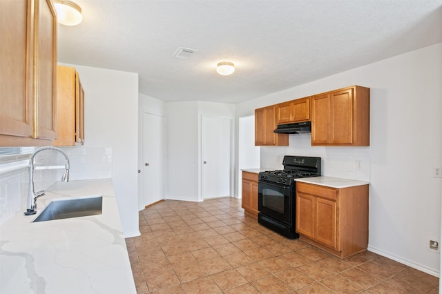 kitchen with tasteful backsplash, sink, light tile patterned floors, and black range with gas stovetop