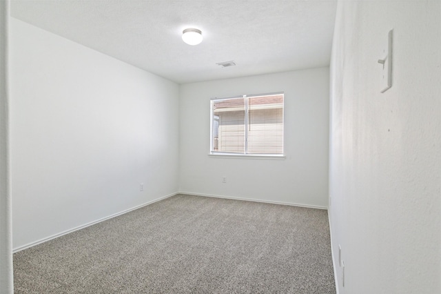 carpeted empty room with a textured ceiling